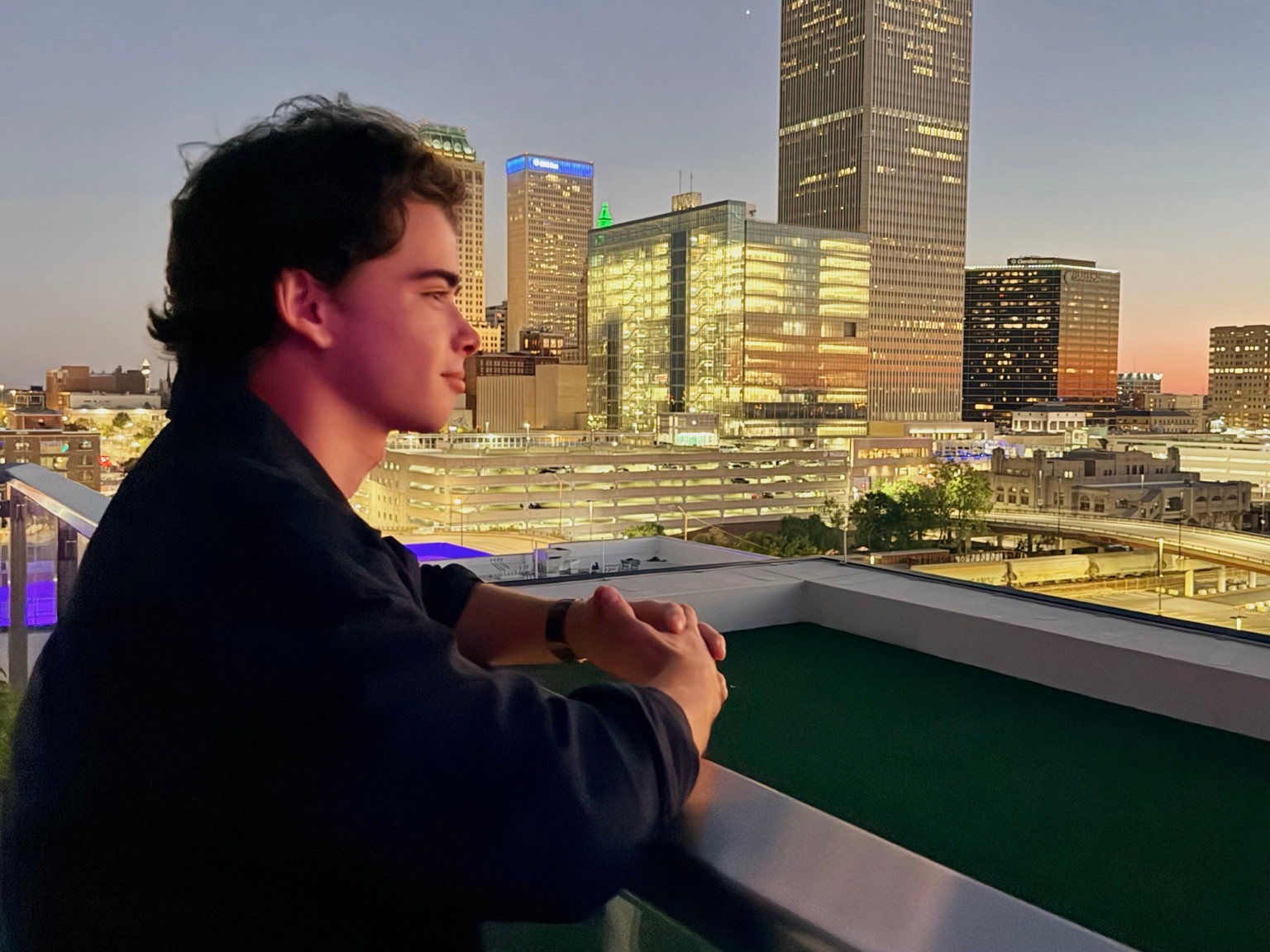 Jack looking out over a city skyline at dusk