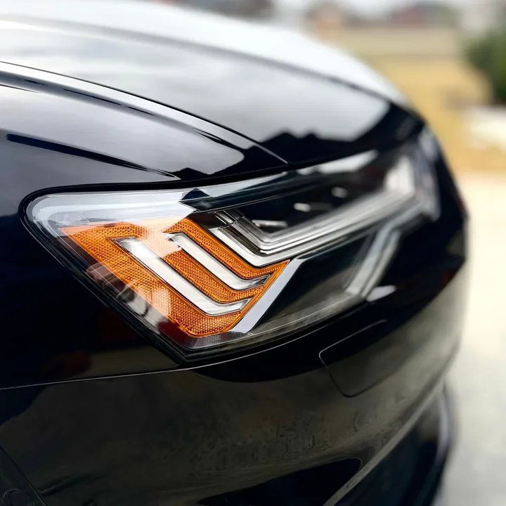 Black Audi headlight and reflective paint close-up