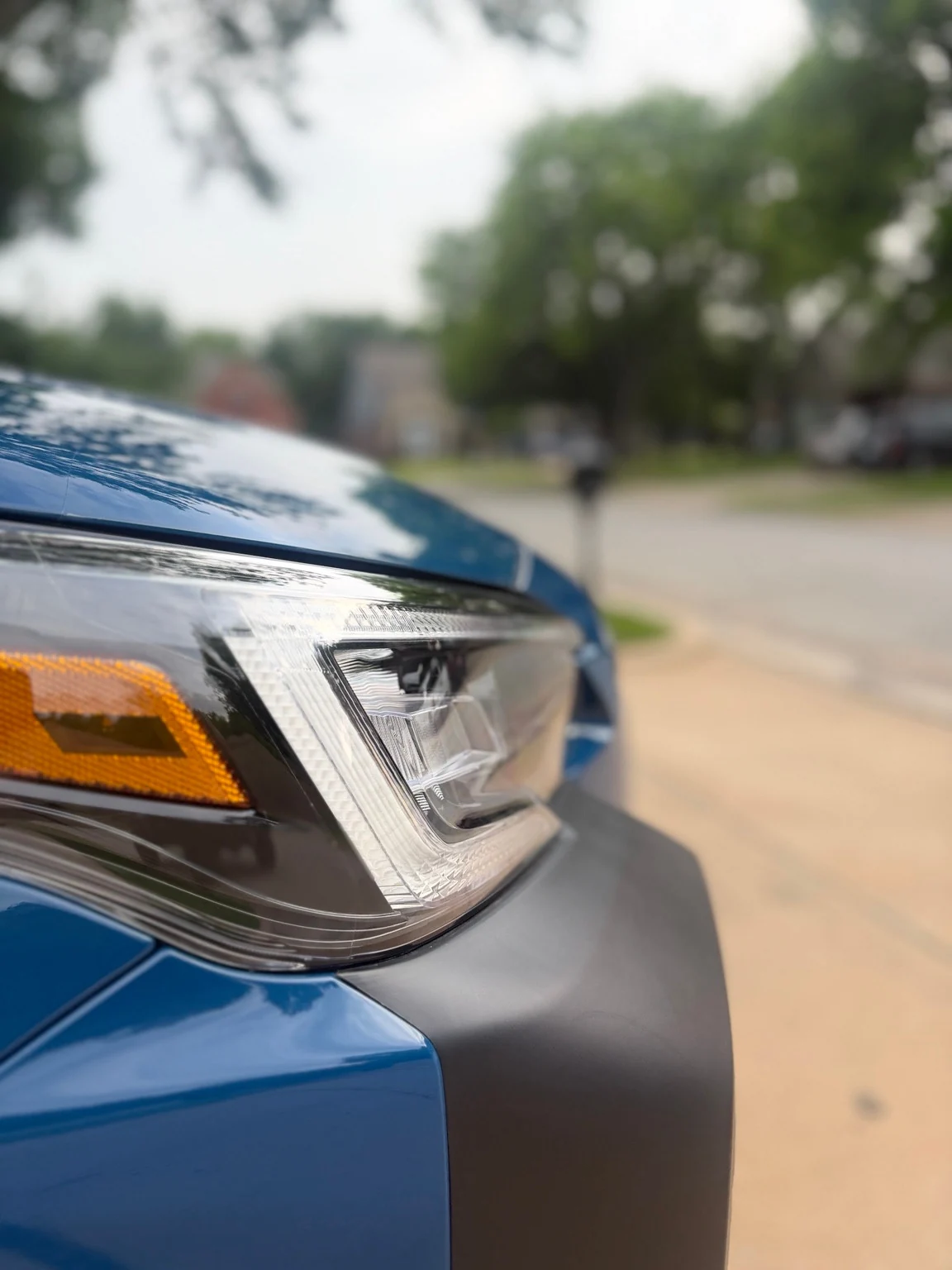 Close view of a clean Subaru headlight and blue paint
