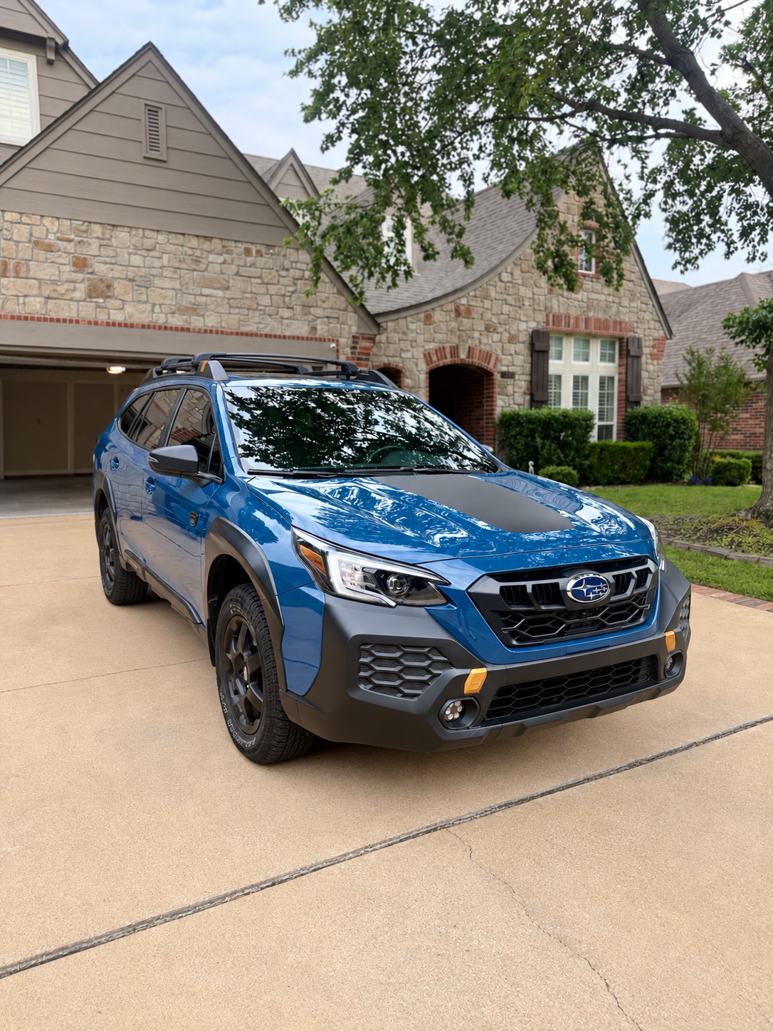 Blue Subaru SUV with reflective paint parked on a driveway