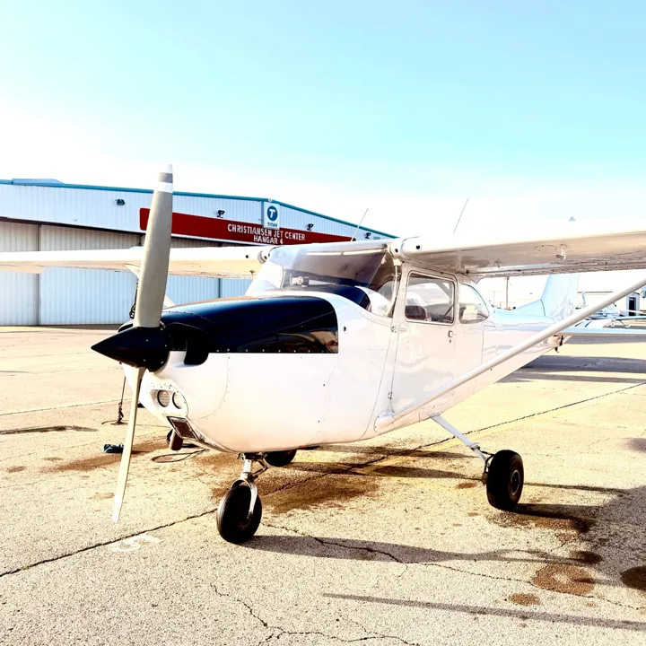 White high-wing aircraft photographed outside a hangar
