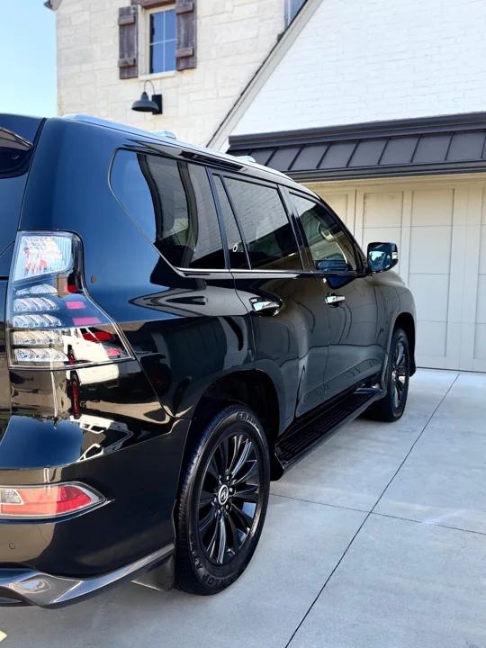 Glossy black Lexus SUV viewed from the rear side