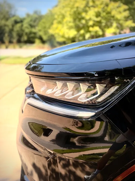 Close-up of a Kia headlight and glossy black finish