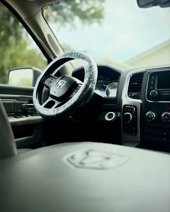 Clean Ram truck cabin with protected steering wheel and leather console