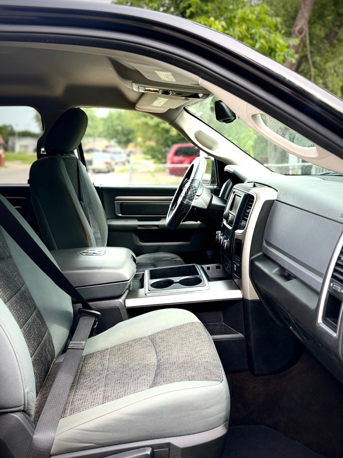 Gray leather passenger seat and center console in a pickup cabin, with the steering wheel covered
