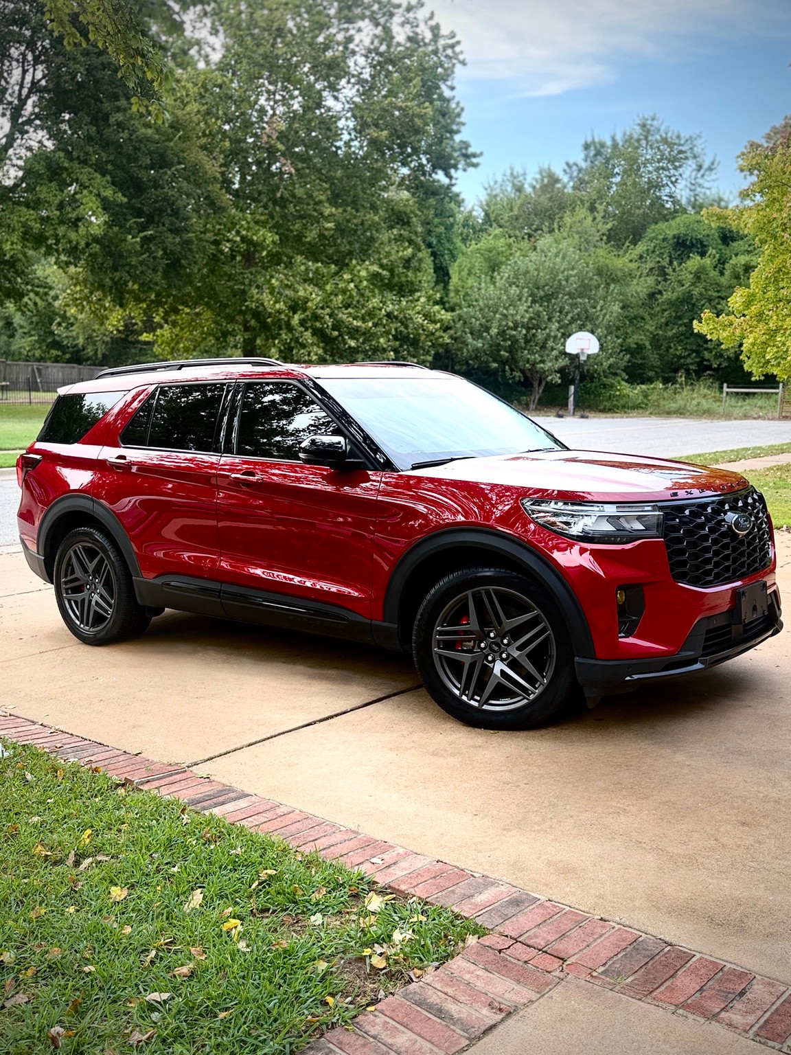 Glossy red Ford Explorer photographed from the front corner, with its roof and both wheels visible