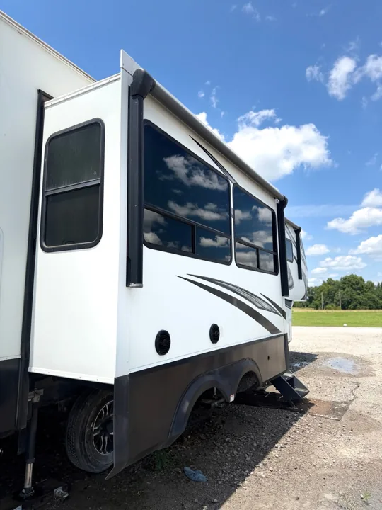 Clean white travel trailer side and extended slide-out