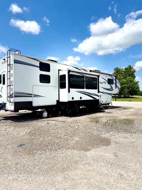 White travel trailer photographed outside beneath a blue sky
