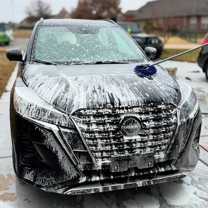Dark SUV grille and hood covered in white wash foam