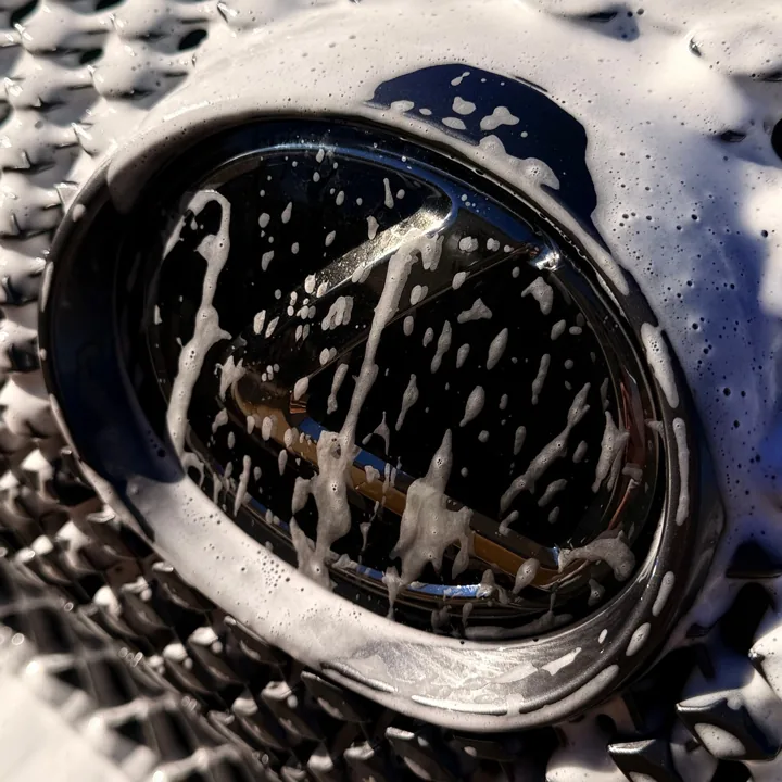 Close-up of a black wheel covered in wash foam